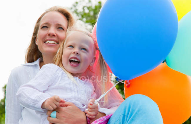 Mãe e filha segurando balões — Fotografia de Stock