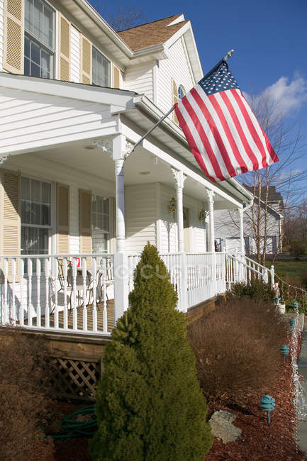 Bandeira americana pendurada fora da casa — Fotografia de Stock