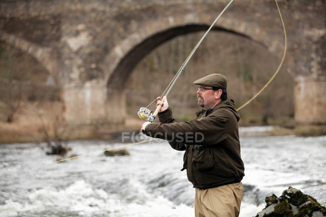 Hombre pescando salmón en el río - foto de stock