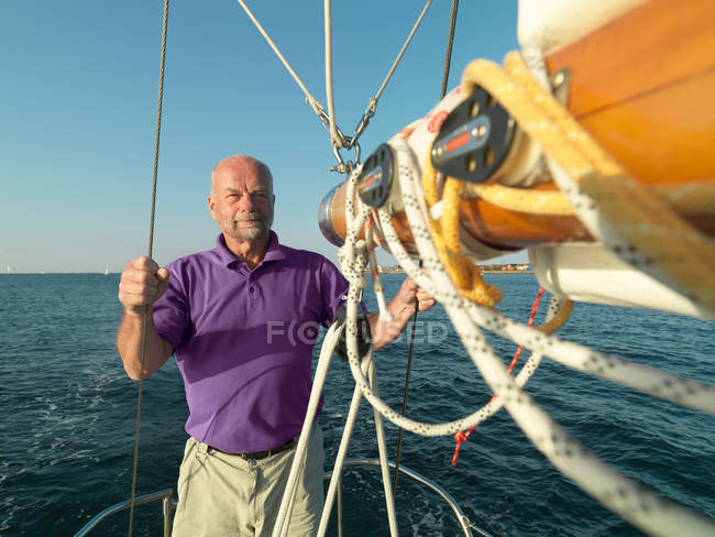 Uomo regolazione sartiame su barca a vela — Foto stock