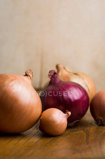 Bunch of mixed onions on table — Stock Photo