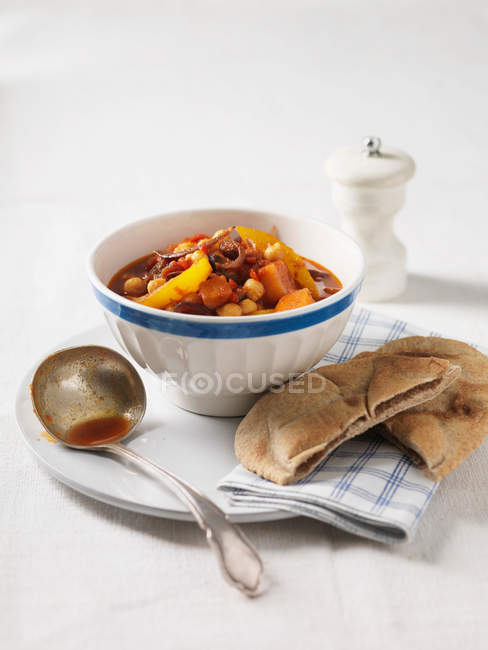 Bowl of chickpea and vegetable stew with ladle — Stock Photo