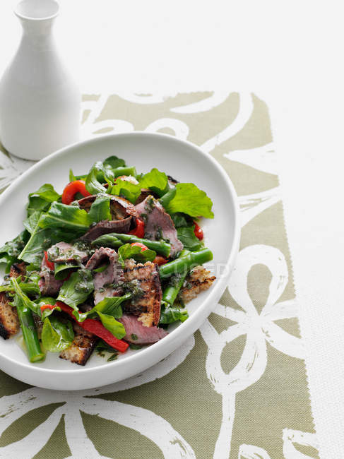 Говядина и салат на тарелке — стоковое фото