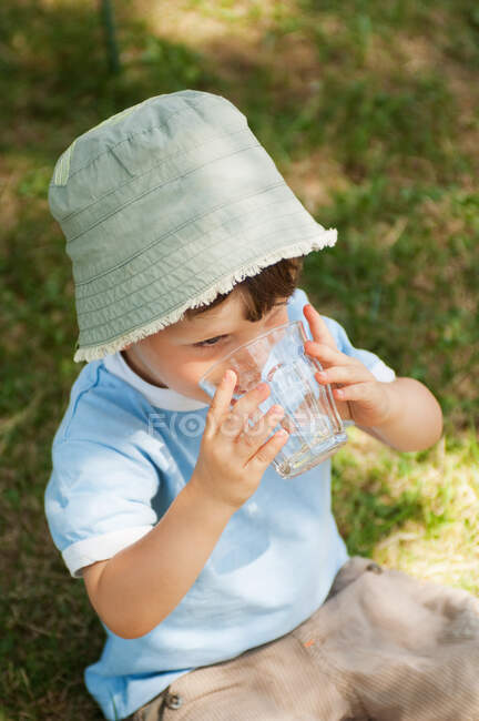 Хлопчик п'є склянку води — стокове фото