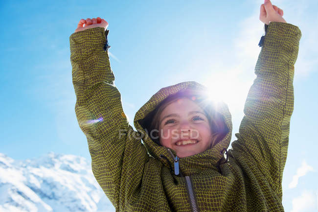 Girl cheering on snowy mountain top — Stock Photo