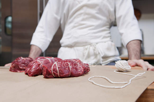 Butcher and beef tenderloin rolled and tied — Stock Photo