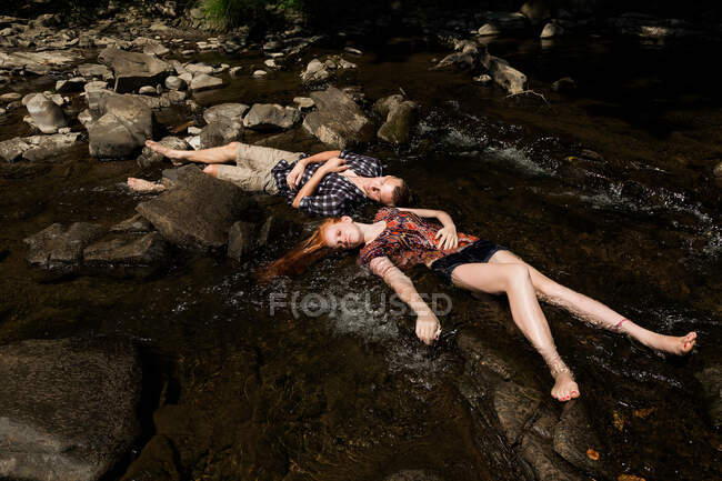 Couple lying down in river — Stock Photo