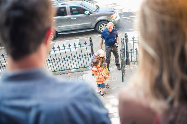 Großeltern kommen, Junge umarmt Großmutter — Stockfoto