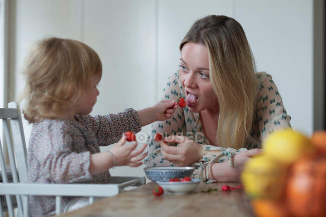 Filha alimentando mãe morangos — Fotografia de Stock