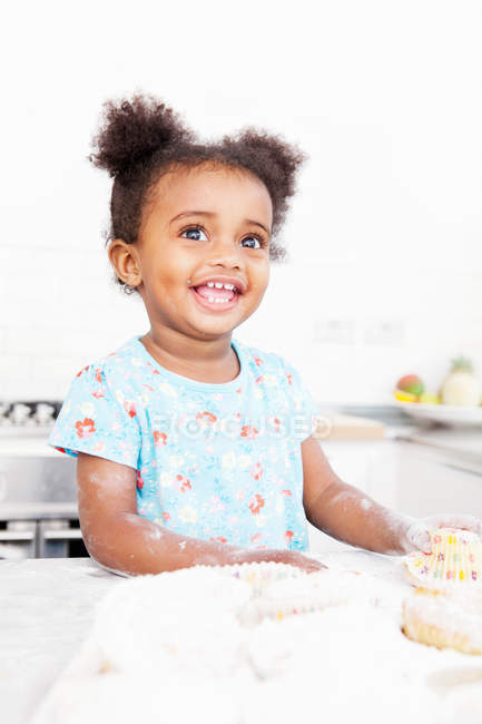 Sorridente ragazza cottura in cucina — Foto stock