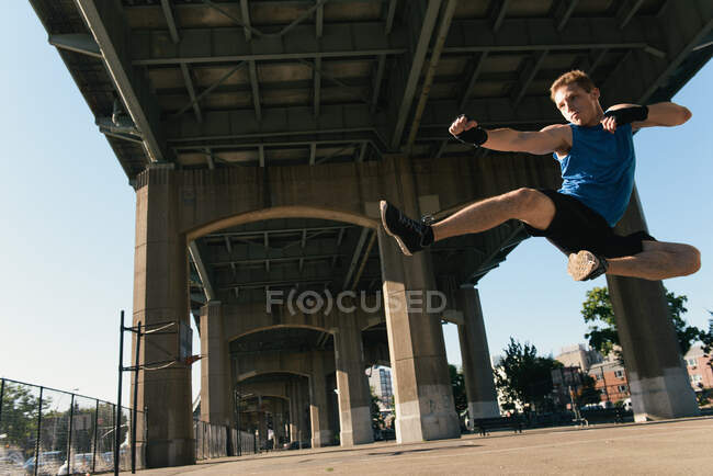 Молодой человек на улице, прыгает, в воздухе — стоковое фото
