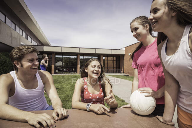 Adolescentes alumnos de secundaria que tienen equipo de voleibol hablar fuera de la escuela - foto de stock