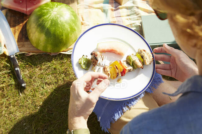 Man with plate of kebab at picnic party — Stock Photo