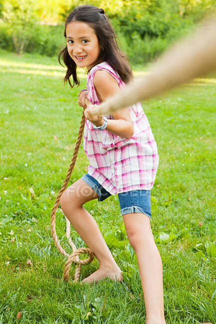 Chica tirando de la cuerda en el juego de tirar de la guerra - foto de stock