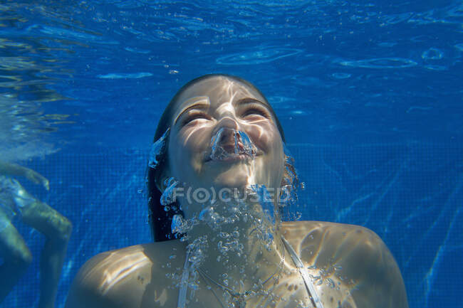 Underwater head and shoulder view of girl underwater swimming in swimming pool — Stock Photo