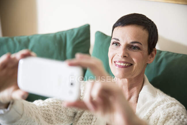 Mulher tomando selfie em casa — Fotografia de Stock