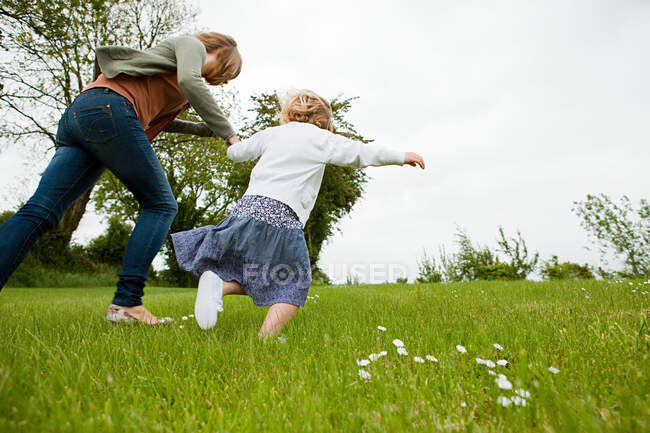 Мать и дочь бегают по полю — стоковое фото