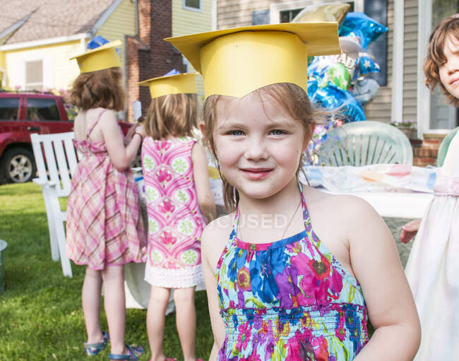 Retrato de menina na graduação do jardim de infância, usando placa de argamassa de papel — Fotografia de Stock
