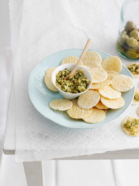 Plate of crackers with topping — Stock Photo