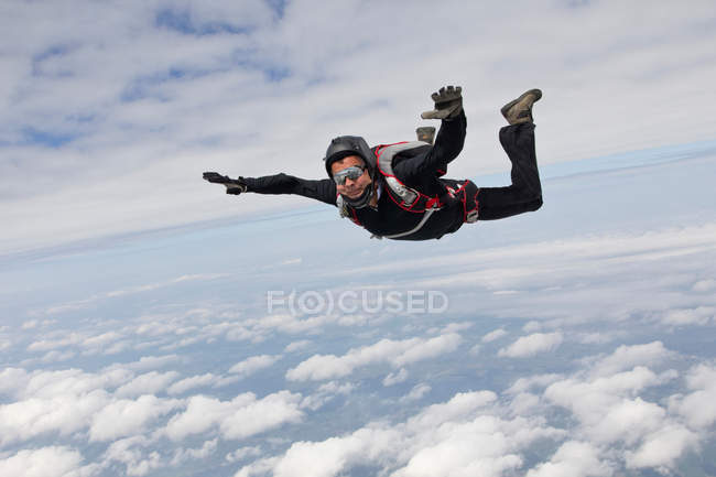 Skydiver Flying In The Sky With Clouds Bavaria Person Stock Photo