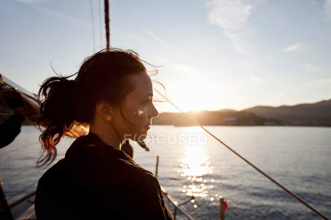 Donna su una barca a guardare il tramonto — Foto stock