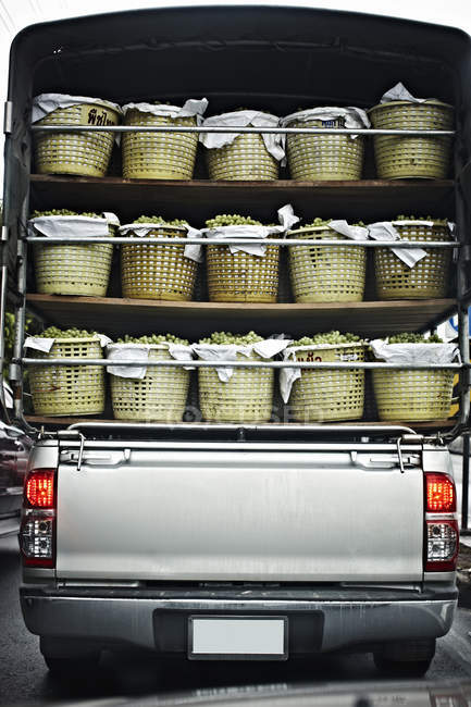 Camión con cestas de uvas maduras en la calle - foto de stock
