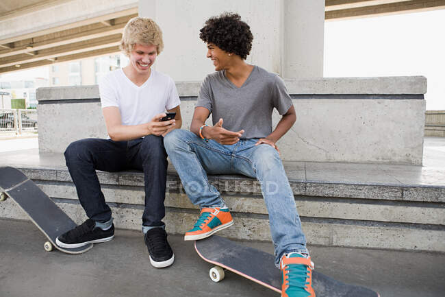 Les garçons adolescents avec skateboards et téléphone portable — Photo de stock