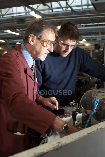 Teacher helping students in shop class — Stock Photo