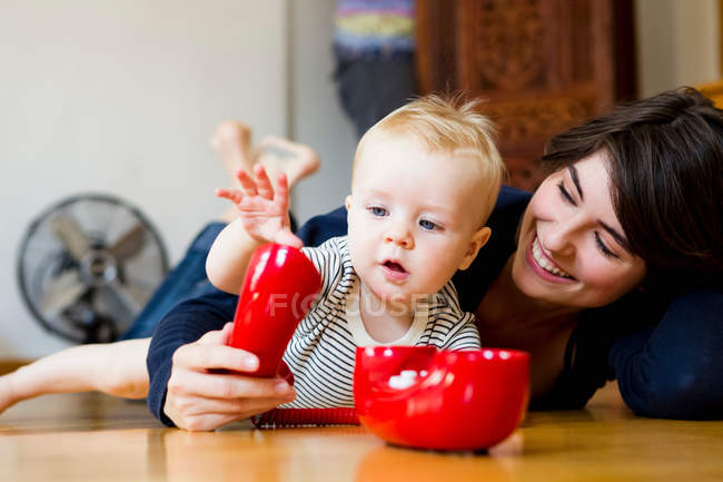 Madre y bebé jugando en el suelo - foto de stock