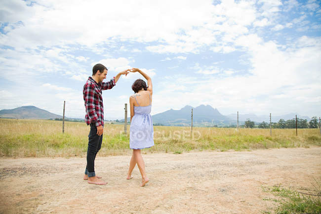 Couple dansant dans un champ — Photo de stock