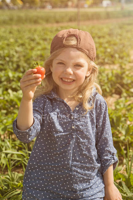 Girl holding fresh picked strawberry — Stock Photo