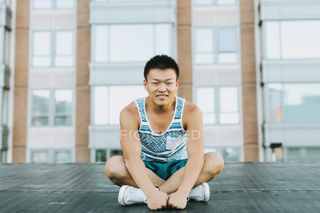 Человек, сидящий скрещенным ногами на бетонном полу, Бостон, Массачусетс, США — стоковое фото