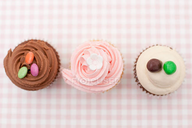 Cupcakes glacés en rangée sur tissu — Photo de stock