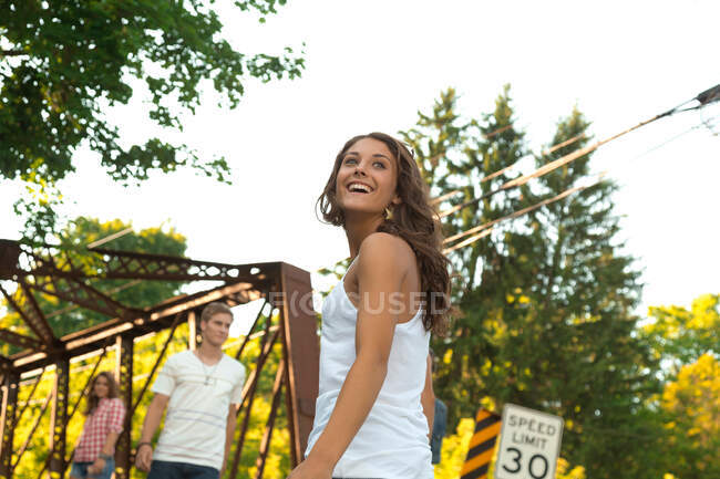 Adolescente chica en puente con amigos - foto de stock