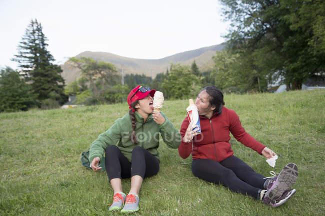 Hikers enjoying ice cream cone on grass, Lake Blanco, Washington, USA — Stock Photo