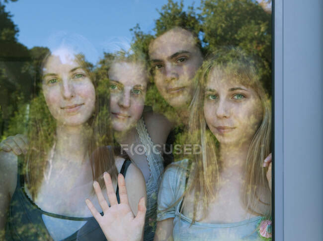Young adults looking through glass door — Stock Photo