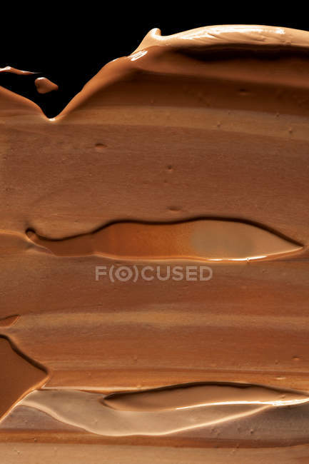 Smeared cosmetic foundation, dark brown tone — Stock Photo