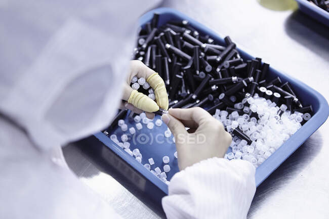 Worker in ecigarette factory, close-up of hands and components — Stock Photo