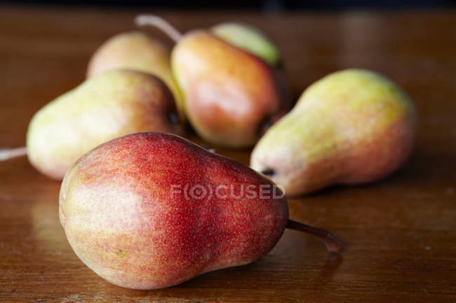 Deliciosas peras sobre mesa marrón - foto de stock
