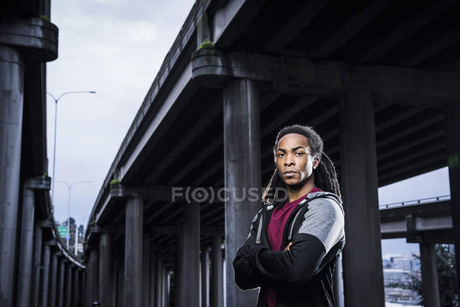 Портрет мужчины-боксера со сложенными руками, стоящего под городской эстакадой — стоковое фото