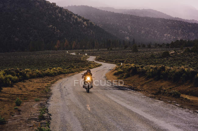 Motorcyclist riding motorbike on open road, Kennedy Meadows, California, USA — Stock Photo