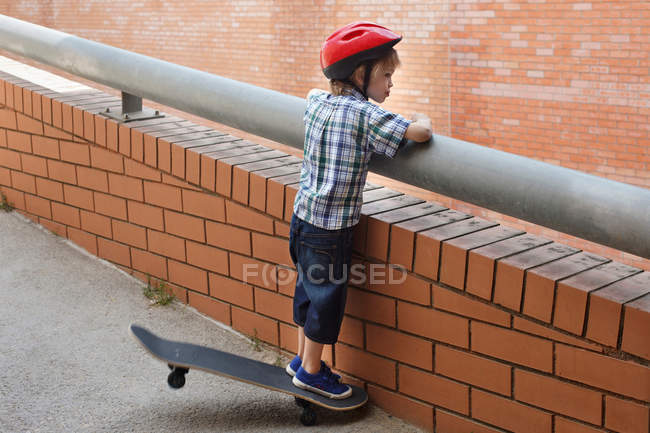 Menino olhando sobre varanda ao ar livre — Fotografia de Stock