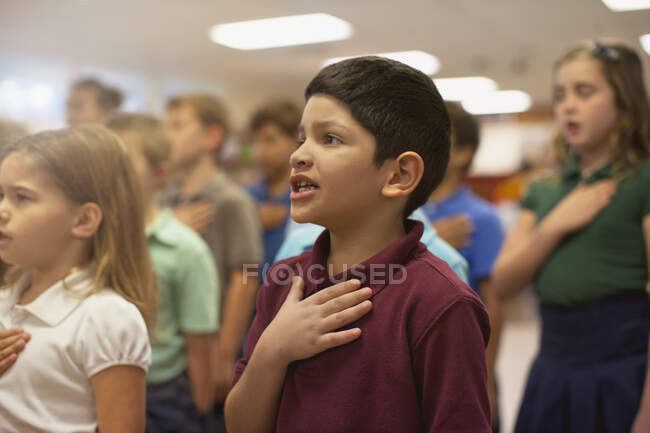 Niños recitando juramento de lealtad en la escuela - foto de stock
