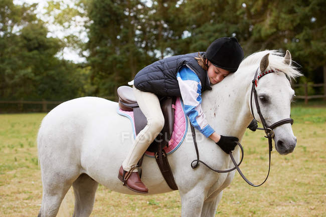 Mädchen kuschelt ihr Pony im Freien — Stockfoto