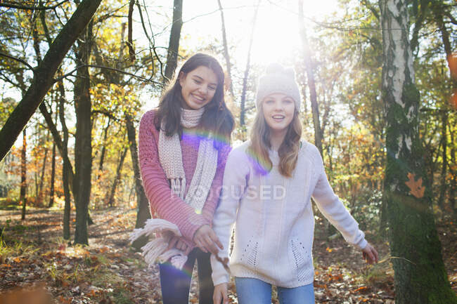Adolescentes na floresta olhando para a câmera sorrindo — Fotografia de Stock