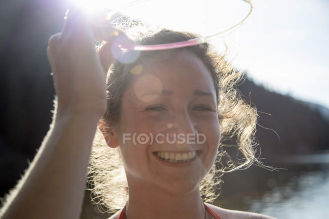 Jovem mulher sorrindo à luz do sol — Fotografia de Stock