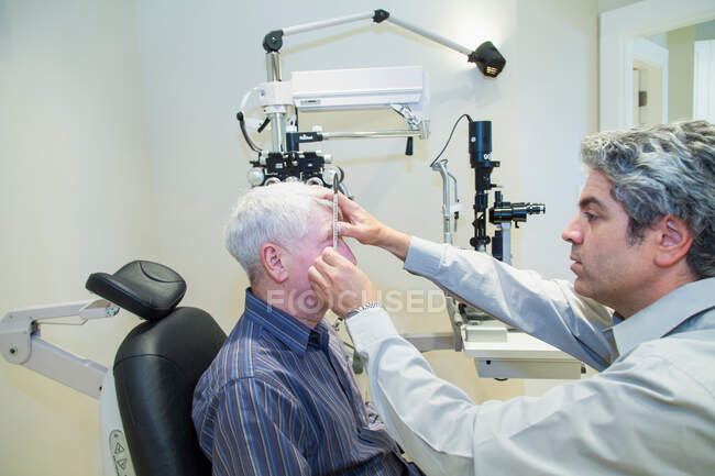 Doctor giving patient eye exam — Stock Photo