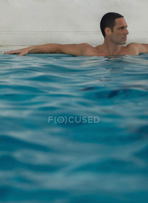 Mann entspannt sich im Infinity-Pool — Stockfoto