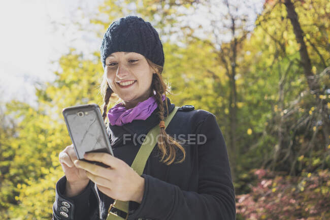 Молодая женщина в сельской местности с помощью смартфона — стоковое фото