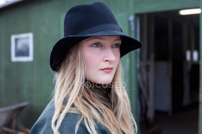 Woman standing outside stable — Stock Photo